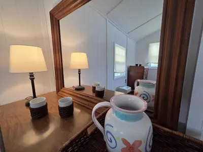 a vase sitting on a table in front of a mirror at Newton Lake in Malinchak Airport