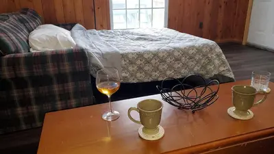 a table with a glass of wine and two cups at Newton Lake in Malinchak Airport