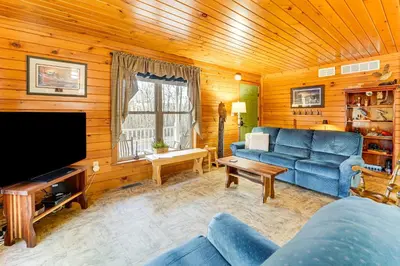 a living room with a blue couch and a television at Hike, Fish and Unwind Home with Fire Pit in Woodward! in Woodward