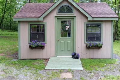 a small house with a green door and flowers at Hike, Fish and Unwind Home with Fire Pit in Woodward! in Woodward