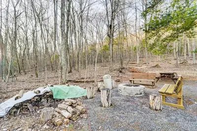 a fire pit and a bench in the woods at Hike, Fish and Unwind Home with Fire Pit in Woodward! in Woodward