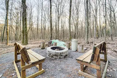 two wooden benches and a fire pit in the woods at Hike, Fish and Unwind Home with Fire Pit in Woodward! in Woodward