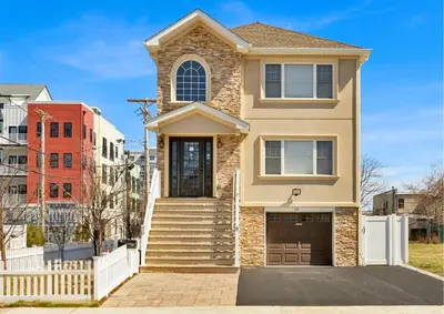 a house with a staircase in front of it at The Seabreeze Haven- Luxury 3BR Coastal Retreat - Near Beach & Free Parking in Keansburg