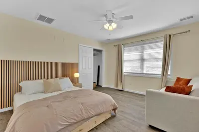 a bedroom with a bed and a couch and a window at The Seabreeze Haven- Luxury 3BR Coastal Retreat - Near Beach & Free Parking in Keansburg