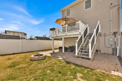 a house with a white staircase and a patio at The Seabreeze Haven- Luxury 3BR Coastal Retreat - Near Beach & Free Parking in Keansburg