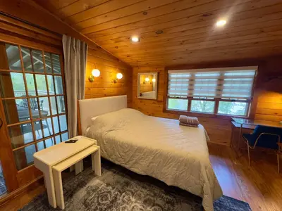 a bedroom with a bed in a wooden cabin at Lakefront Cabin with Hot Tub, Views & Fireplace in Lake Harmony