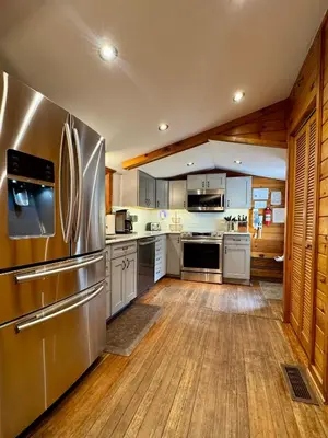 a large kitchen with a stainless steel refrigerator at Lakefront Cabin with Hot Tub, Views & Fireplace in Lake Harmony