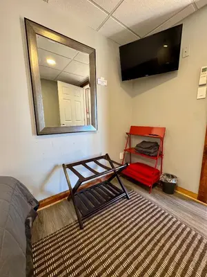 a room with a bed and a mirror and a red shelf at Lake View Cottage - Private Dock and Fire Pit in Lake Harmony