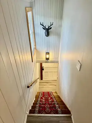 a hallway with stairs with a reindeer head on the wall at Lake View Cottage - Private Dock and Fire Pit in Lake Harmony
