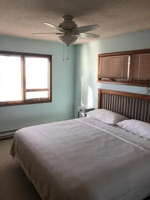 a bedroom with a large white bed with a ceiling fan at Great Value - Oceanside Raised Ranch Location Is Perfect For Walking To Beach, Restaurants, Pizza, Ice Cream Or Coffee 13419 in Upper Greenwood Lake