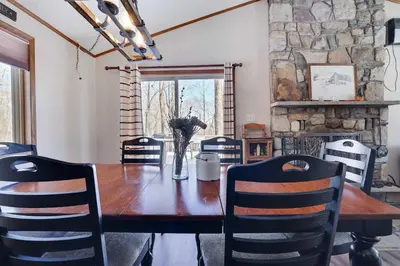 a dining room with a wooden table and chairs at 4 Br Cozy Cabin Sleeps 8 Pool Table Arcade Beach in Gouldsboro