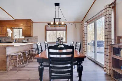 a kitchen and dining room with a wooden table and chairs at 4 Br Cozy Cabin Sleeps 8 Pool Table Arcade Beach in Gouldsboro