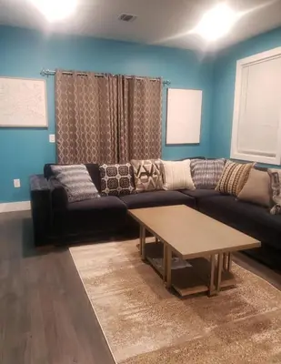 a living room with a black couch and a coffee table at Comfy 3 bedroom house in Newark