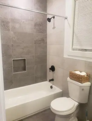 a bathroom with a toilet and a tub and a sink at Comfy 3 bedroom house in Newark