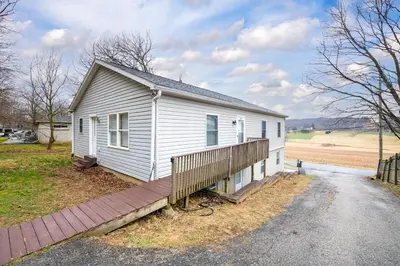 a small white house with a wooden porch at Comfortable & Healthy Home in Parkesburg