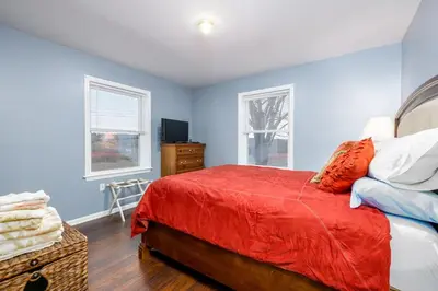 a bedroom with a red bed and blue walls at Comfortable & Healthy Home in Parkesburg