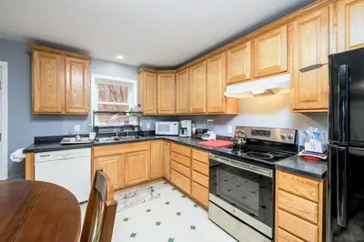 a kitchen with wooden cabinets and a table at Comfortable & Healthy Home in Parkesburg