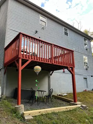 a deck on a house with a table and chairs at Spacious and tranquil 5br house in charming East Stroudsburg w game room, pets allowed in East Stroudsburg