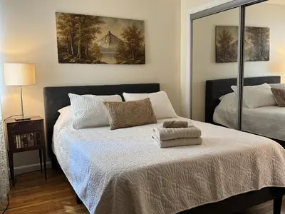 a bedroom with a bed and a painting on the wall at NY - NJ Tennis Suites - Sleeps 40 - 15 Mins to NYC in Union City