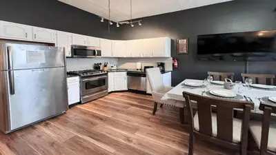 a kitchen with a stainless steel refrigerator and a table with chairs at Max NY VIEW 5 Apartment Combo Sleeps 60 15 Mins to NYC in Union City