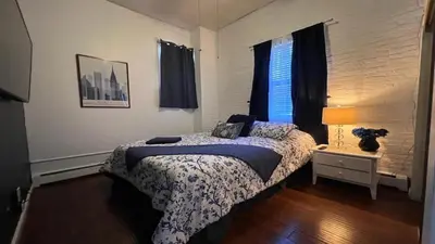 a bedroom with a bed and a lamp and a window at Max NY VIEW 5 Apartment Combo Sleeps 60 15 Mins to NYC in Union City