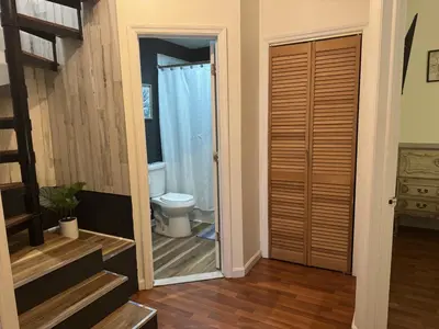 a bathroom with a toilet and a door leading to a bathroom with a shower at Max NY VIEW 5 Apartment Combo Sleeps 60 15 Mins to NYC in Union City