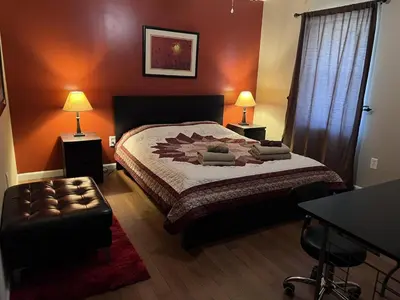 a bedroom with a bed and a table and two lamps at Ultra Spacious Penthouse - Apt 2 - 3 Combo -15 Mins from NYC in Union City
