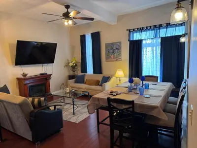 a living room with a table and a couch and a television at Triple See NY Now - Sleeps 41 -15 Mins to NYC in Union City