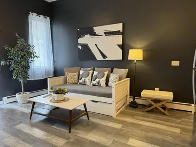 a living room with a couch and a table at Triple See NY Now - Sleeps 41 -15 Mins to NYC in Union City