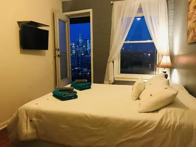 a bedroom with a large white bed with a window at Mega Stunning Skyline View - APT 4-5 Combination - 6 Bedroom - Sleeps 25 - 15 mins to NYC in Union City