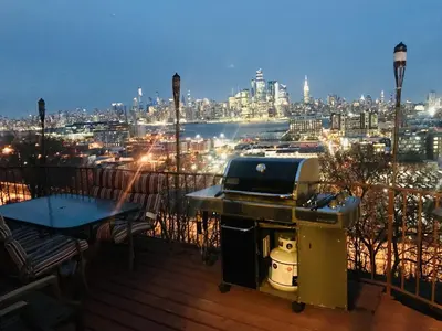 a grill on a balcony with a view of a city at Mega Stunning Skyline View - APT 4-5 Combination - 6 Bedroom - Sleeps 25 - 15 mins to NYC in Union City