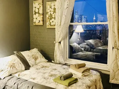 a bedroom with a window with towels on a bed at Mega Trade Stunning View - APT 3-4 Combination in Union City
