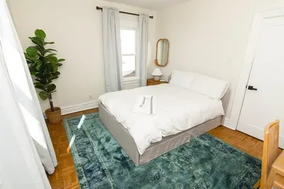 a bedroom with a white bed with a tray on it at Spacious Beach Vibe Newark's Hidden Gem in Newark