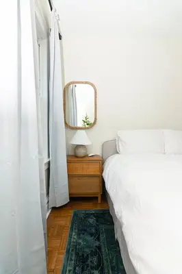 a white bedroom with a bed and a mirror at Spacious Beach Vibe Newark's Hidden Gem in Newark