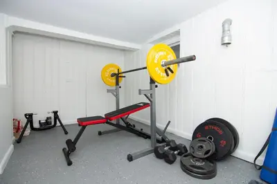 a room with a gym with a squat rack and weights at Spacious Beach Vibe Newark's Hidden Gem in Newark