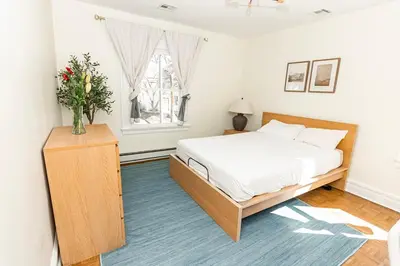 a bedroom with a bed and a vase of flowers at Spacious Beach Vibe Newark's Hidden Gem in Newark