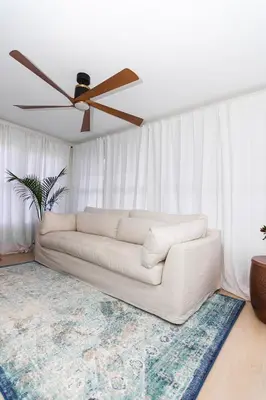 a white couch in a living room with a ceiling fan at Spacious Beach Vibe Newark's Hidden Gem in Newark