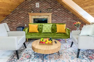 a living room with a green couch and a table at Spacious 3BR Oasis with Patio & Arcade Fun in Philly in Philadelphia