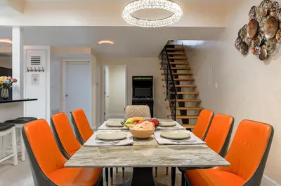 a dining room with a table and orange chairs at Spacious 3BR Oasis with Patio & Arcade Fun in Philly in Philadelphia