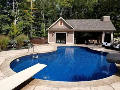 a swimming pool in front of a house at Glamorous Cottage Rental with Outdoor Lounge and Pool on 40 Acres in Pine Bush, New York in Pine Bush