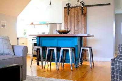 a kitchen with a blue island with bar stools at Stylish Cottage Loft Rental on a Farm in Lancaster County near Philadelphia, Pennsylvania in Christiana