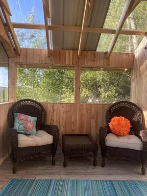 two wicker chairs sitting on a screened porch at Gorgeous Finger Lakes Accommodation near Ithaca for Glamping in New York in Brooktondale