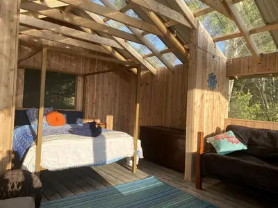 a bedroom with a bed in a wooden cabin at Gorgeous Finger Lakes Accommodation near Ithaca for Glamping in New York in Brooktondale
