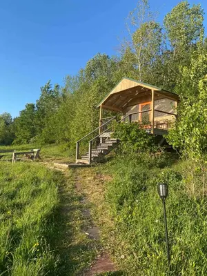 a wooden cabin on a hill with a path leading to it at Gorgeous Finger Lakes Accommodation near Ithaca for Glamping in New York in Brooktondale