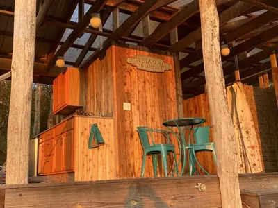 a wooden house with two chairs and a table at Gorgeous Finger Lakes Accommodation near Ithaca for Glamping in New York in Brooktondale