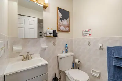 a bathroom with a toilet and a sink and a mirror at 3BR Stay for Crews & Families in Elizabeth