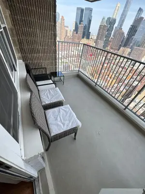 a balcony with two chairs and a couch on a building at Midtown High Floor Fantastic Panoramic City View Corner 2 Bedroom Apartment in New York