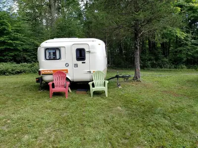 three chairs sitting in front of a white caravan at Unique Caravan for Vintage Glamping Experience in Pine Bush, New York in Pine Bush