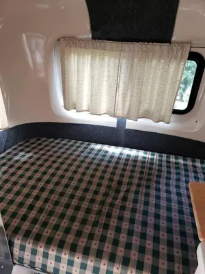 a bed in the back of a camper with a window at Unique Caravan for Vintage Glamping Experience in Pine Bush, New York in Pine Bush