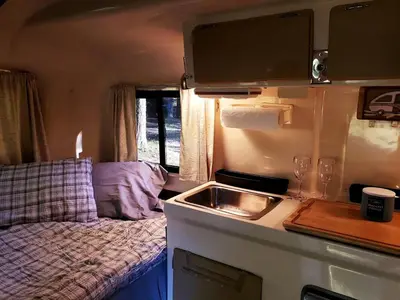 a kitchen with a sink and a bed in a caravan at Unique Caravan for Vintage Glamping Experience in Pine Bush, New York in Pine Bush